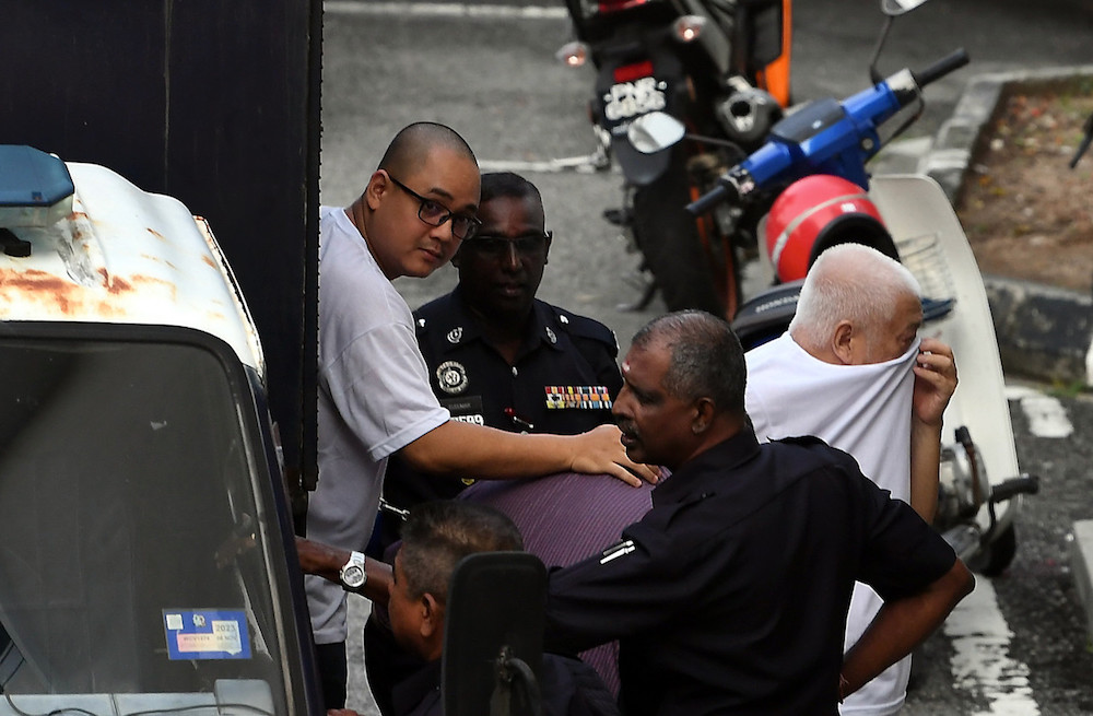 Penang NRD assistant director Mohd Faizul Arifin (left) arrives in a police truck for a court appearance at the Penang High Court in George Town October 3, 2019. u00e2u20acu201d Bernama pic