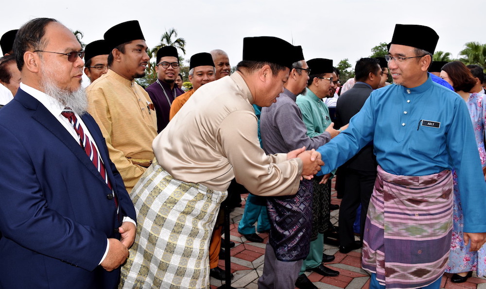 Melaka Chief Minister Adly Zahari (right) greets people during the Melaka State Government Monthly Assembly in Melaka October 4, 2019. u00e2u20acu201d Bernama pic