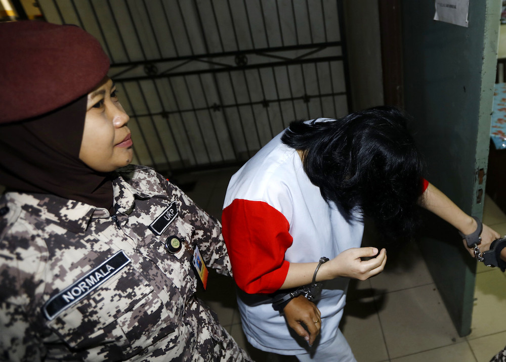 Ling Hang Tsyr dodges photographers as she leaves the Court of Appeal in Kuching October 8, 2019. u00e2u20acu201d Bernama pic