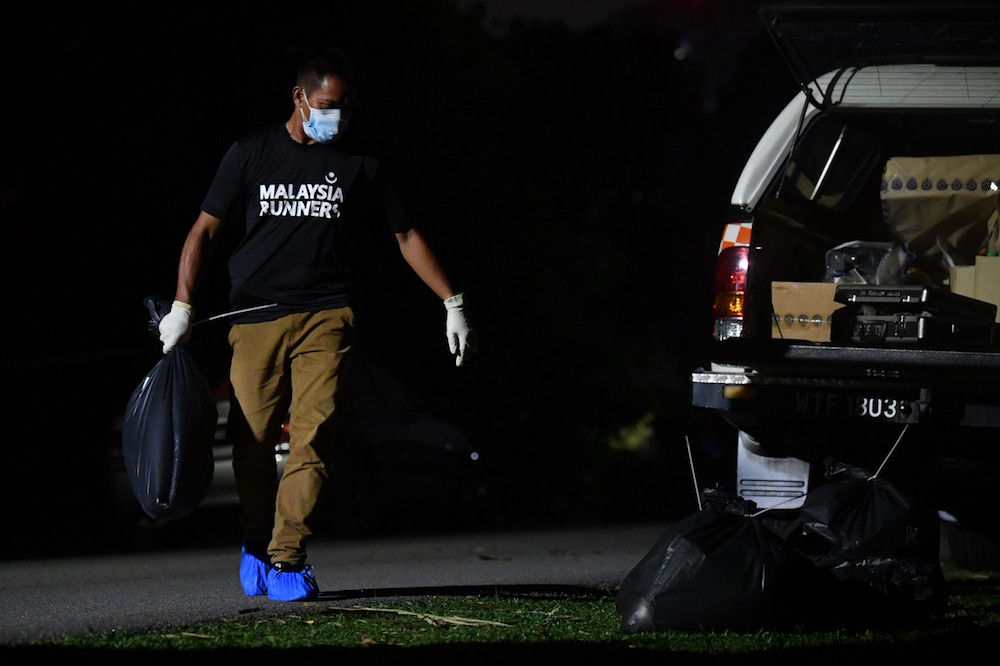 A policeman carries a bag believed to contain a dismembered body part in Kampung Ladang Krubong, Melaka October 10, 2019. u00e2u20acu201d Bernama pic