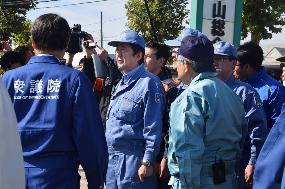 Japanu00e2u20acu2122s Prime Minister Shinzo Abe (centre) inspects an area hit by Typhoon Hagibis last week in Koriyama, Fukushima prefecture October 12, 2019. u00e2u20acu201d Jiji Press pic via AFP