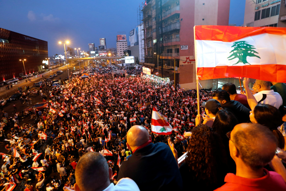 Demonstrators carry national flags during an anti-government protest along a highway in Jal el-Dib, Lebanon October 21, 2019. u00e2u20acu201d Reuters pic