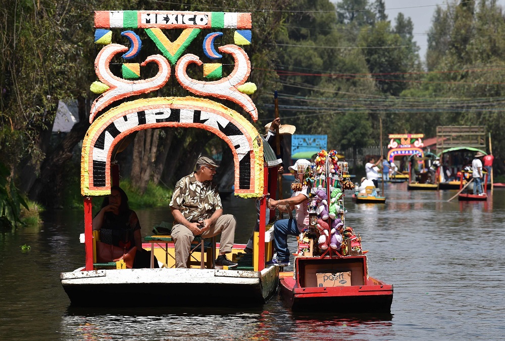 A vendor offers products to visitors aboard a u00e2u20acu02dctrajinerau00e2u20acu2122 as they sail in Xochimilco, Mexico City October 5, 2019. u00e2u20acu2022 AFP pic  
