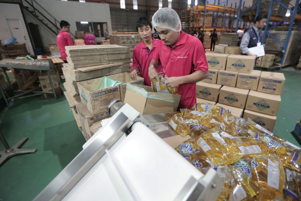 Workers at the Soon Hup Oil factory are pictured packaging subsidised cooking oil November 9, 2016. — Picture by Azinuddin Ghazali
