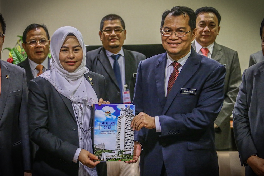 PAC chairman Datuk Noraini Ahmad and Auditor-General Datuk Nik Azman Nik Abdul Majid pose with a copy of the Auditor-Generalu00e2u20acu2122s 2018 Report in Parliament October 14, 2019. u00e2u20acu201d Picture by Hari Anggara