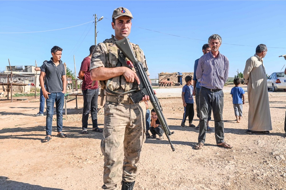 A Turkish soldier stands in front of Turkish villagers during Turkeyu00e2u20acu2122s first joint patrol with US soldiers under a deal reached between Washington and Ankara at the border with Syria near Akcakale, in the Sanliurfa province of Turkey. u00e2u20acu201d AFP pic