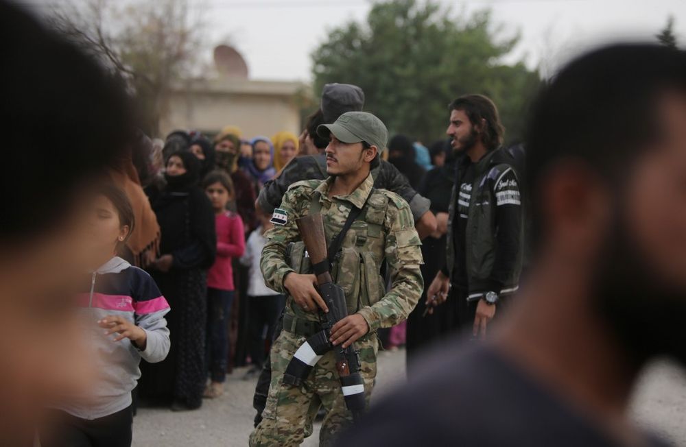 A member of the Turkey-backed forces looks on during the distribution of aid provided by the Turkish Red Crescent to displaced civilians, on October 19, 2019, in the Syrian border town of Tal Abyad. u00e2u20acu201d AFP pic
