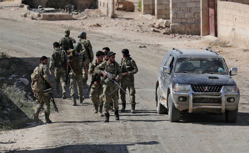 Turkey-backed Syrian rebel fighters walk together near the border town of Tel Abyad, Syria, October 12, 2019. u00e2u20acu201d Reuters pic