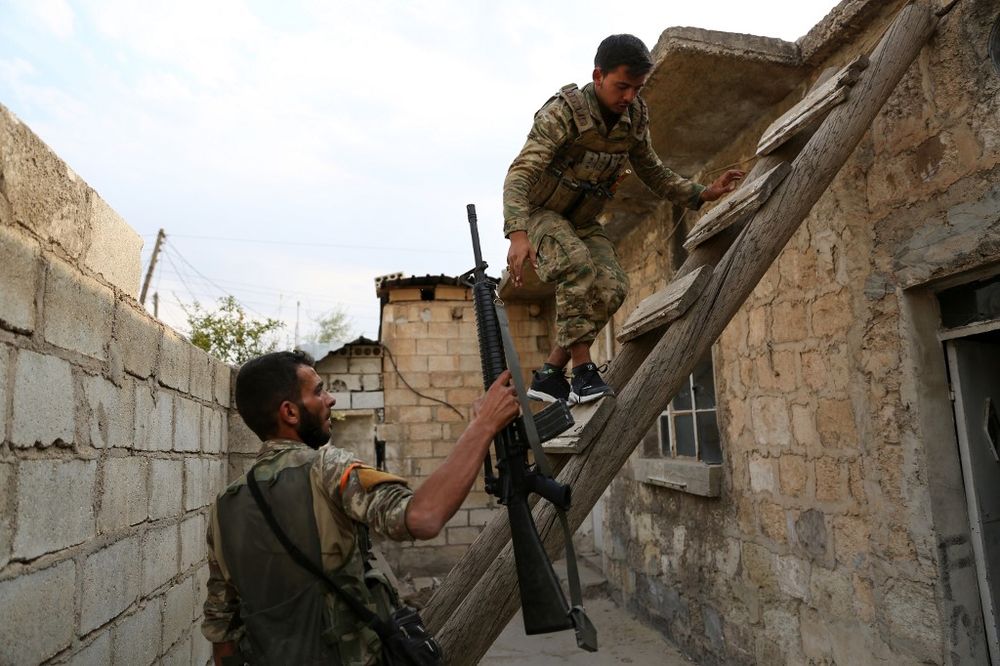 Turkey-backed Syrian fighters climb to the roof of a house in the Syrian border town of Ras al-Ain on October 19, 2019. u00e2u20acu201d AFP pic