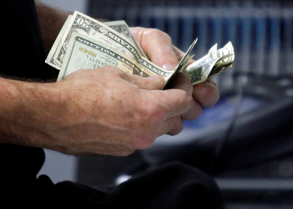 A customer counts his cash at the register while purchasing an item at a Best Buy store in Flushing, New York March 27, 2010. u00e2u20acu201d Reuters pic