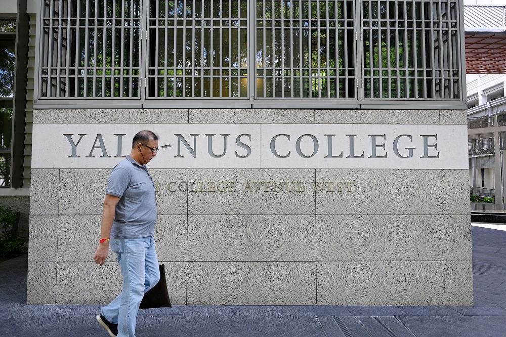 This picture taken on October 14, 2019, shows a man walking past signage for the Yale-NUS College in Singapore. u00e2u20acu201d AFP pic