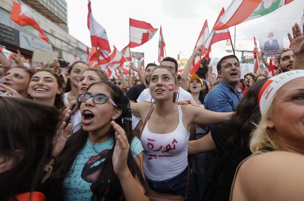 Lebanese demonstrators wave national flags on a highway linking Beirut to north Lebanon, in Zouk Mosbeh, October 19, 2019, a day after demonstrations swept through the eastern Mediterranean country in protest against dire economic conditions. u00e2u20acu201d AFP pic