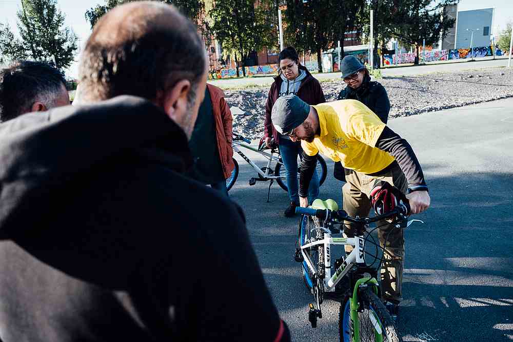 Sami (front right), one of the teachers of the Let's Ride project, shows the different parts of the bicycle to a group of immigrants, in Merihaka area in Helsinki. u00e2u20acu201d AFP pic