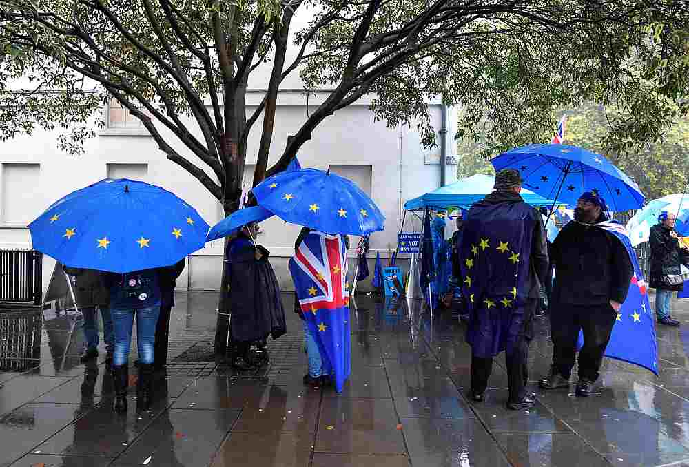 Anti-Brexit and pro-EU protesters shelter from the rain outside the Houses of Parliament in London, October 24, 2019. u00e2u20acu201d Reuters pic