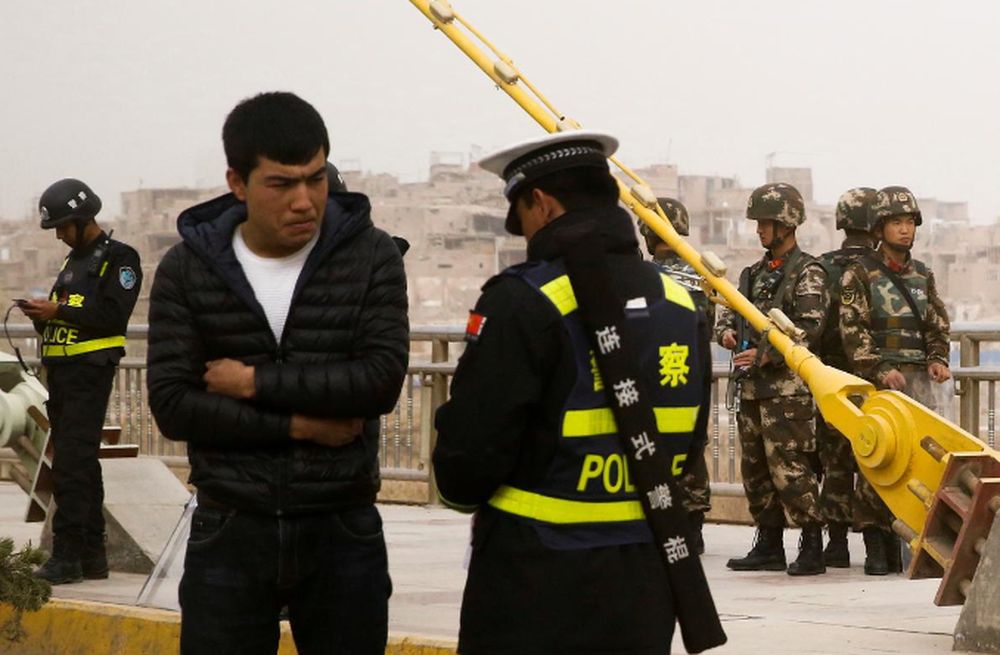 File picture shows a police officer checking the identity card of a man as security forces keep watch in a street in Kashgar, Xinjiang Uighur Autonomous Region, China, March 24, 2017. u00e2u20acu201d Reuters pic