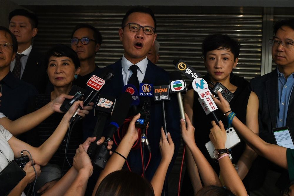 Lawmaker Dennis Kwok (centre) speaks to journalists outside the High Court as he and some 23 other lawmakers seek an emergency injunction in a bid to overturn a face mask ban, in Hong Kong, October 6, 2019. u00e2u20acu201d AFP pic