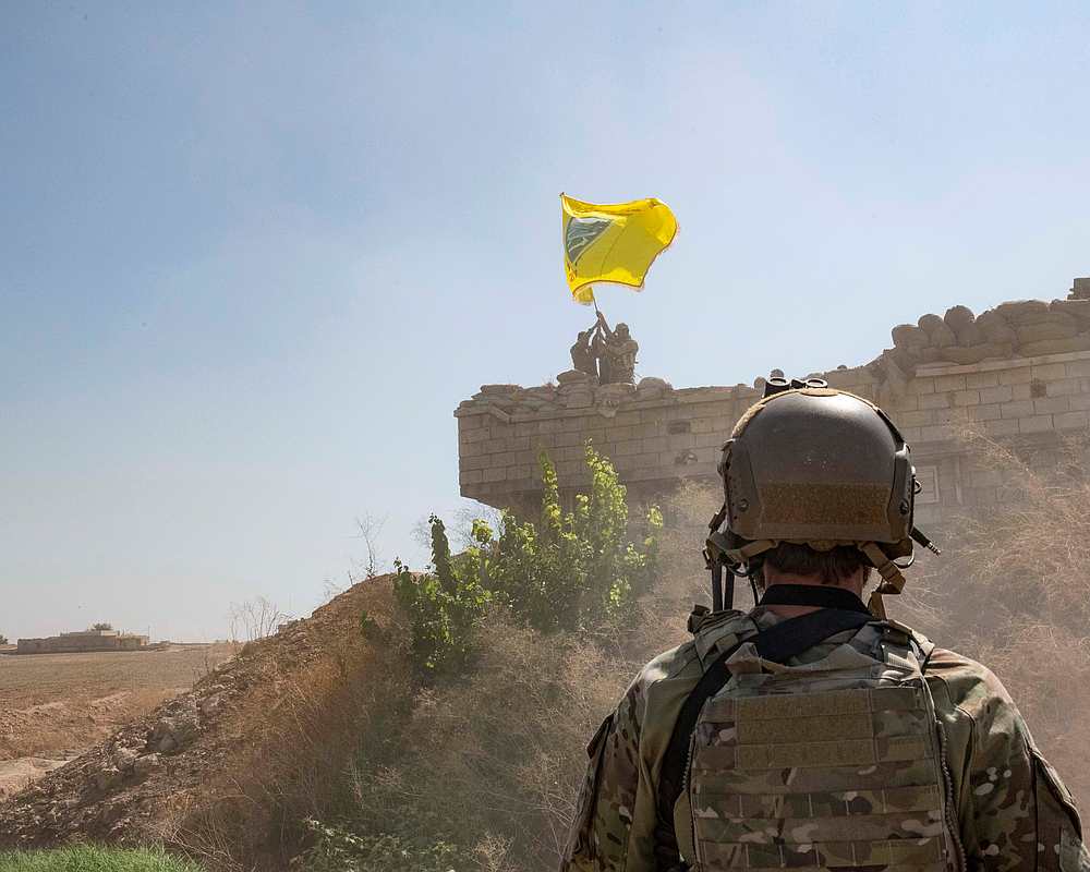A US soldier oversees members of the Syrian Democratic Forces demolishing a YPG fortification and raising a Tal Abyad Military Council flag over the outpost in Syria September 21, 2019. u00e2u20acu201d US Army/Staff Sgt Andrew Goedl/Handout via Reuters