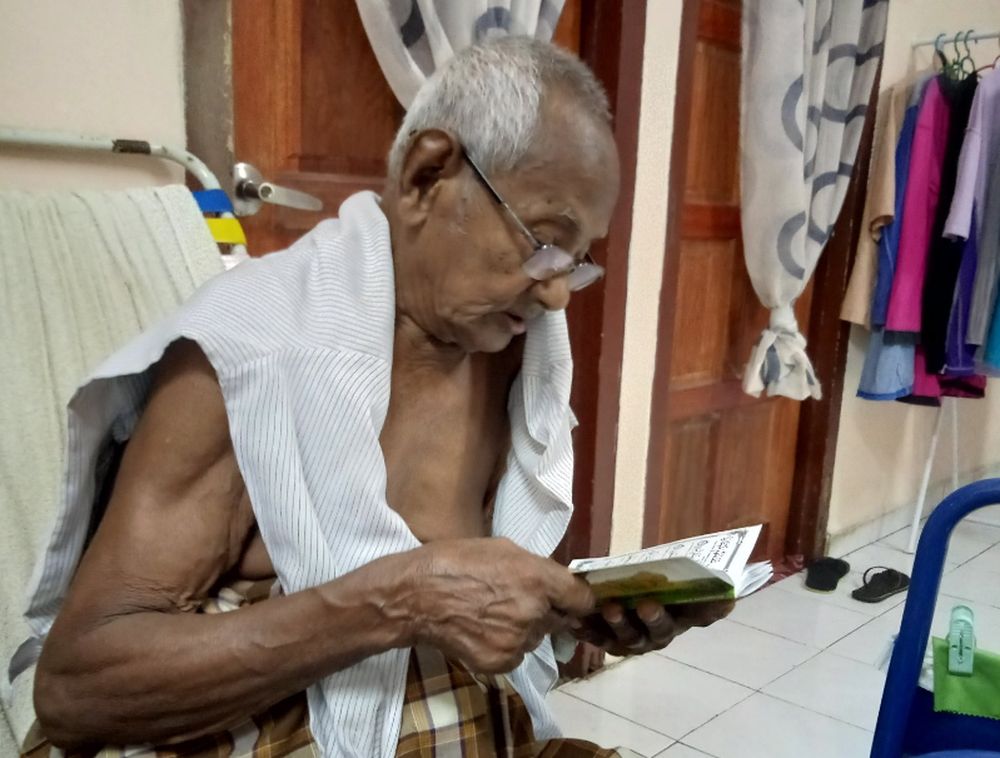 Ibnuu00e2u20acu2122s grandfather sits quietly on his chair while reading prayers from the Quran for his late wife. u00e2u20acu201d Picture via Twitter/@UltrazAcez