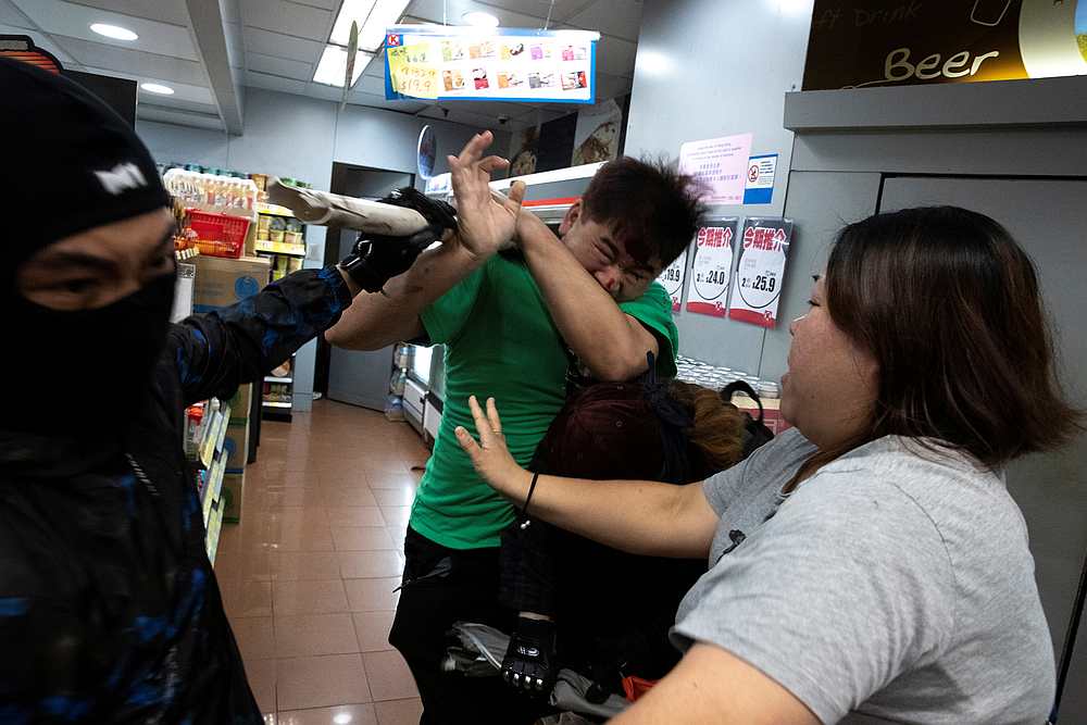 An anti-government protester hits a man during a protest at Tseung Kwan O district, in Hong Kong October 13, 2019. u00e2u20acu201d Reuters pic