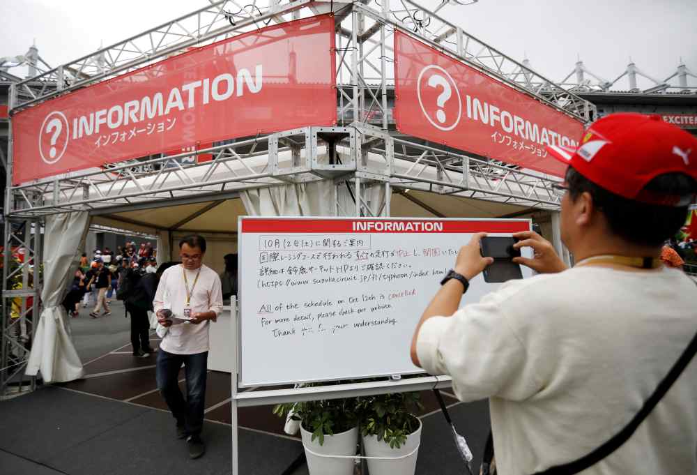 A spectator takes photos of an information board announcing the cancellation of all practice and qualifying sessions scheduled for tomorrow due to the approach of Typhoon Hagibis, at Formula One Japanese Grand Prix in Suzuka October 11, 2019. u00e2u20acu2022 Reuters 
