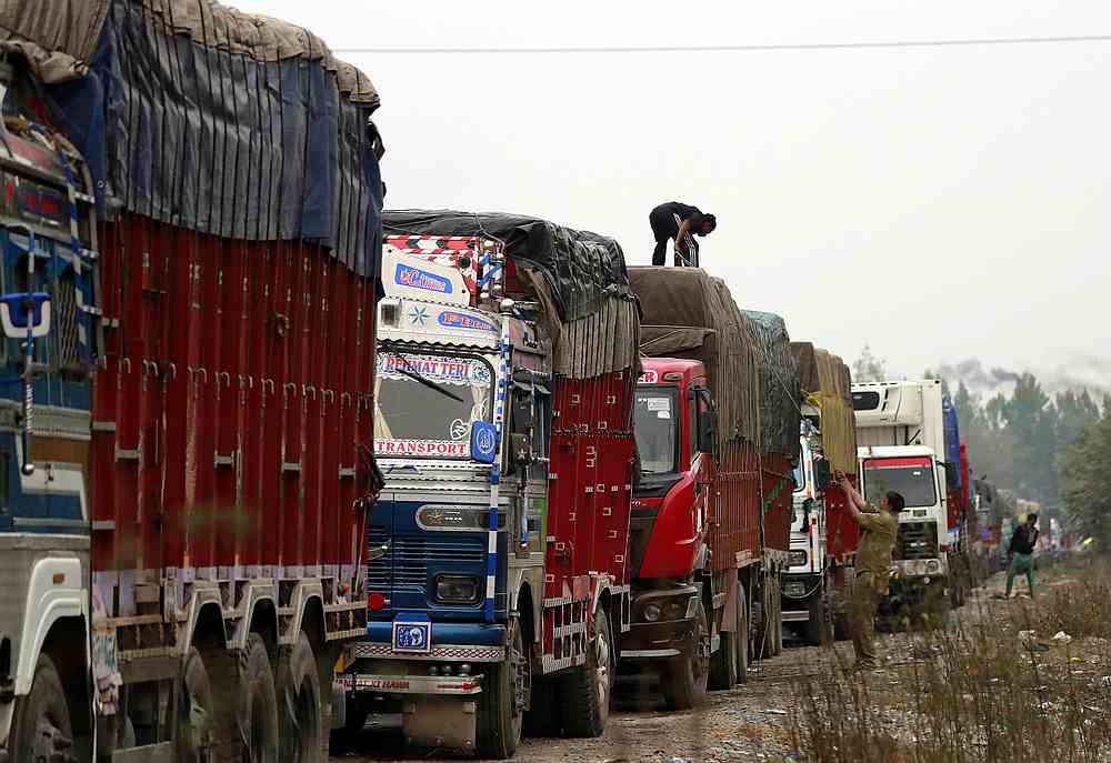 A driver covers a supply truck loaded with apples on a highway near Qazigund in south Kashmir's Anantnag district October 17, 2019. u00e2u20acu201d Reuters pic 