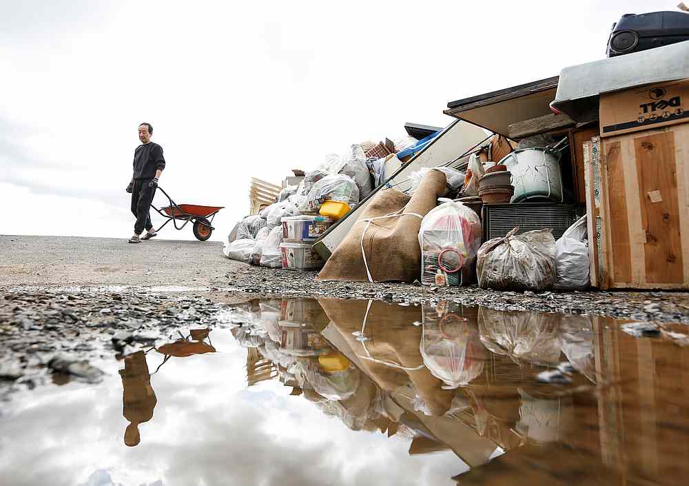 A man pulls a wheelbarrow, in the aftermath of Typhoon Hagibis, in Koriyama, Fukushima prefecture, Japan October 15, 2019. u00e2u20acu201d Reuters
