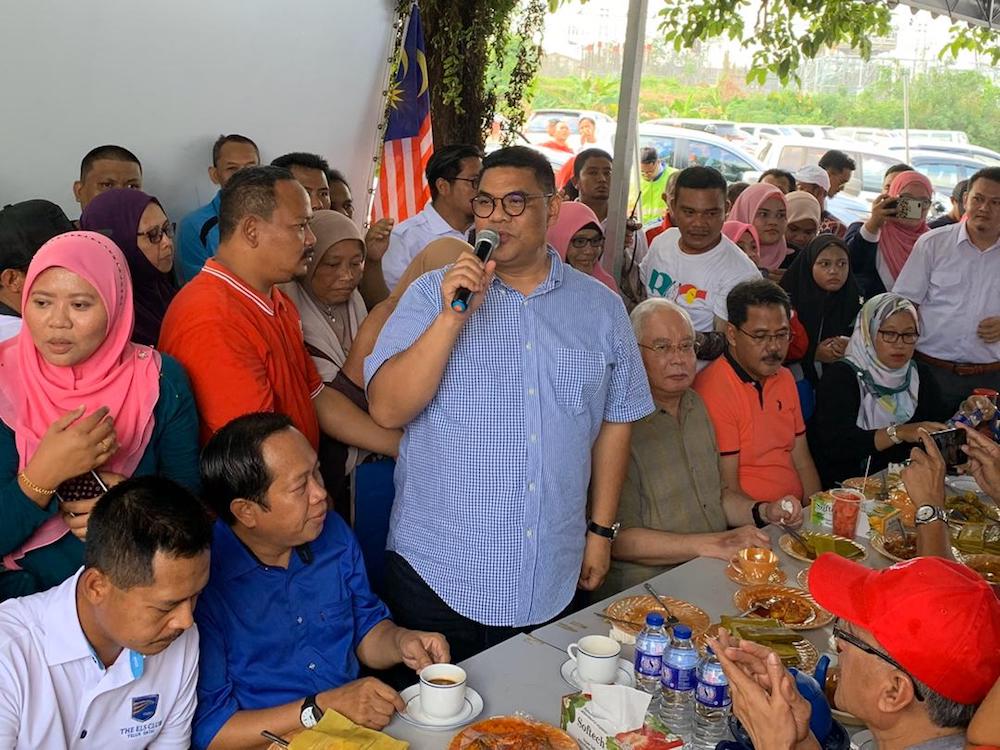 Tanjung Piai Umno division chief Datuk Jefridin Atan (standing, centre) gives a speech to welcome former prime minister Datuk Seri Najib Razak to Burasak Abah in Pekan Nenas, Tanjung Piai today. u00e2u20acu201d Picture by Ben Tan
