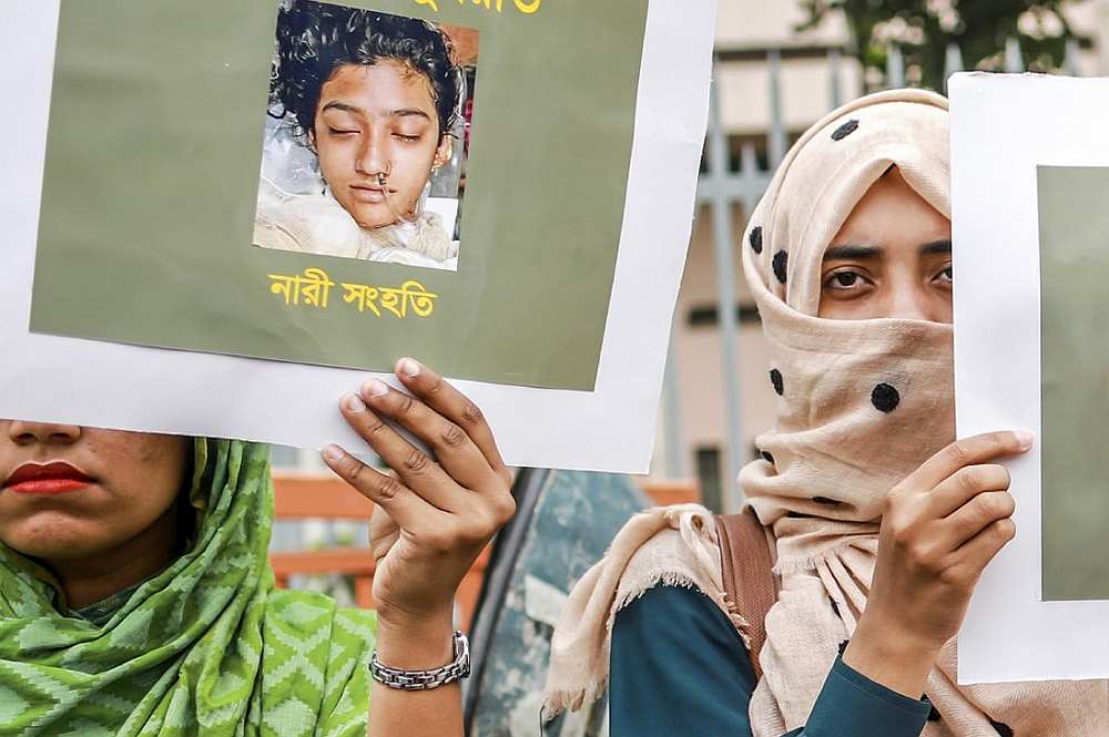 Women hold placards with a photograph of schoolgirl Nusrat Jahan Rafi at a protest in Dhaka on April 12, 2019, following her murder by being set on fire after she had reported a sexual assault. u00e2u20acu201d AFP pic