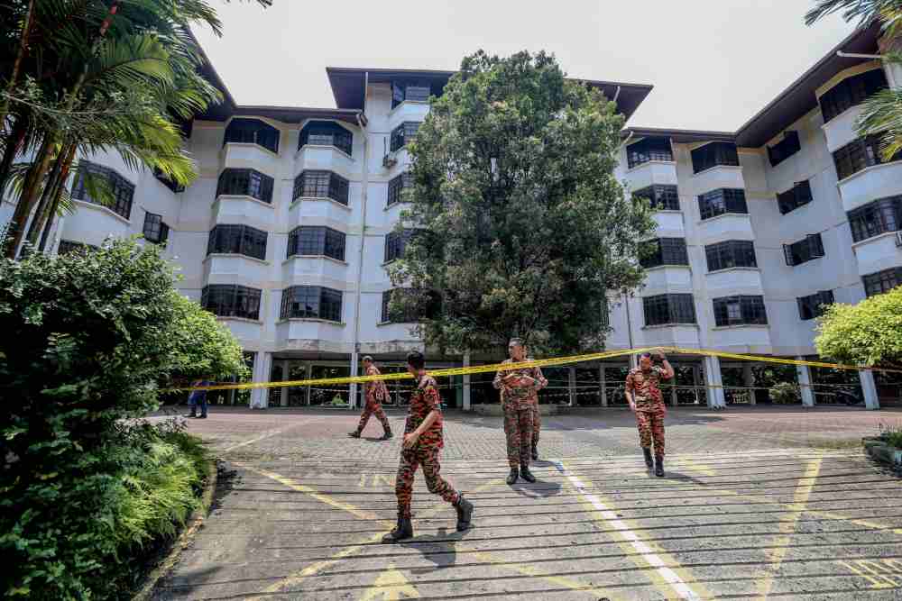Fire and Rescue Department personnel cordon off Azalea Apartments in Kampung Sri Penchala, Kuala Lumpur with yellow tape following a landslide October 11, 2019. — Picture Firdaus Latif