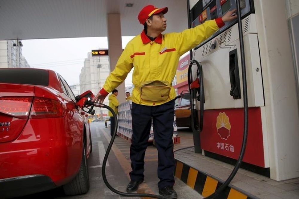 A gas station attendant pumps fuel into a customeru00e2u20acu2122s car at PetroChinau00e2u20acu2122s petrol station in Beijing, China, March 21, 2016. u00e2u20acu201d Reuters