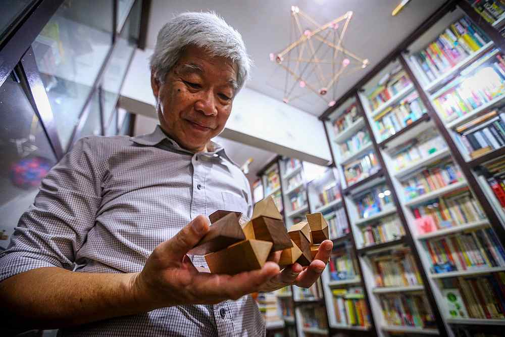 Lee playing with one of his favourite Japanese interlocking wooden puzzles from his collection. — Picture by Hari Anggara