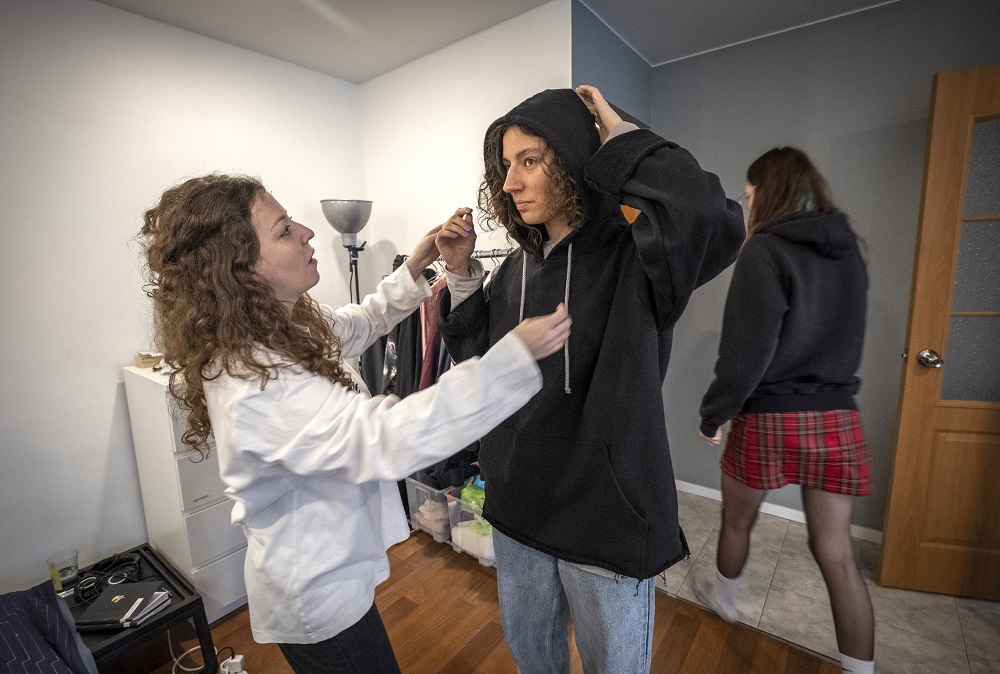 Fashion designer Alina Muzychenko (left) adjusts a garment on a model in her Moscow flat September 17, 2019. ― AFP pic