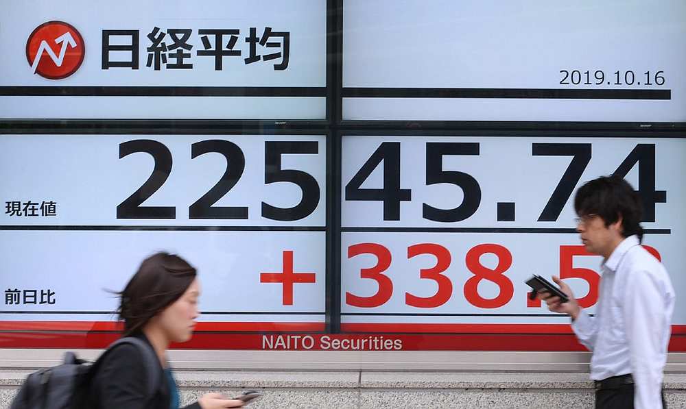 Pedestrians walk in front of an electric quotation board displaying the numbers on the Nikkei 225 index on the Tokyo Stock Exchange October 16, 2019. u00e2u20acu201d AFP pic
