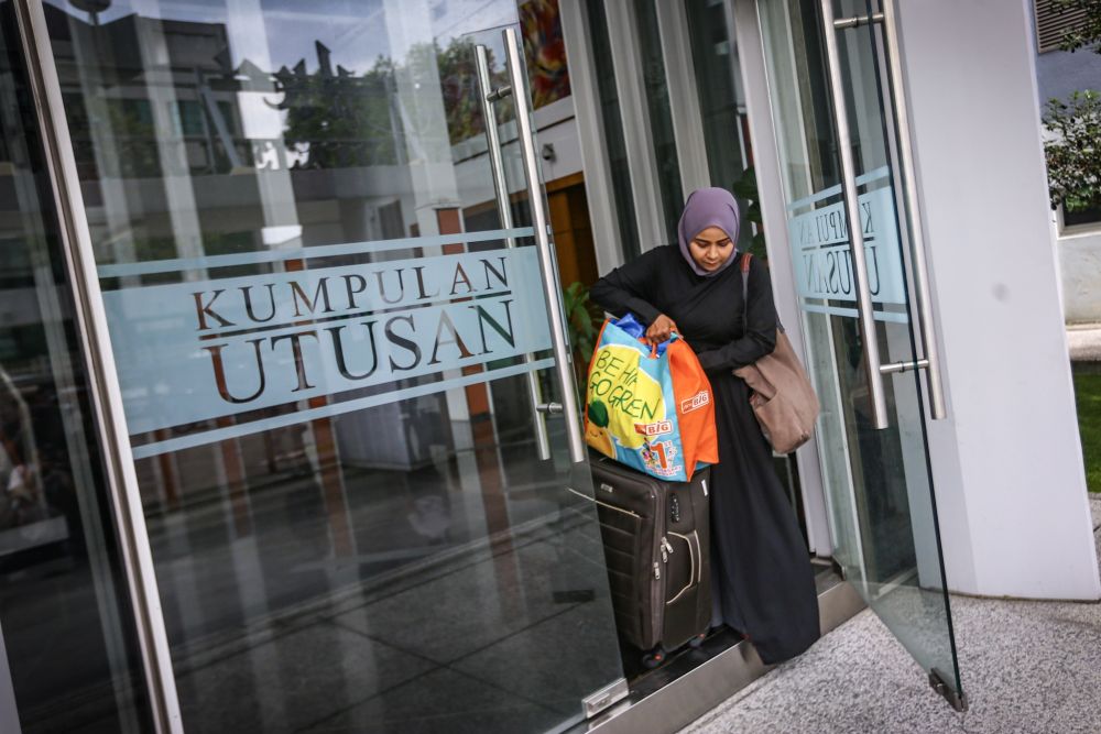 An employee is seen leaving the Utusan Melayu building with her belongings after the newspaper ceased operations on October 9, 2019. u00e2u20acu201d Picture by Hari Anggara