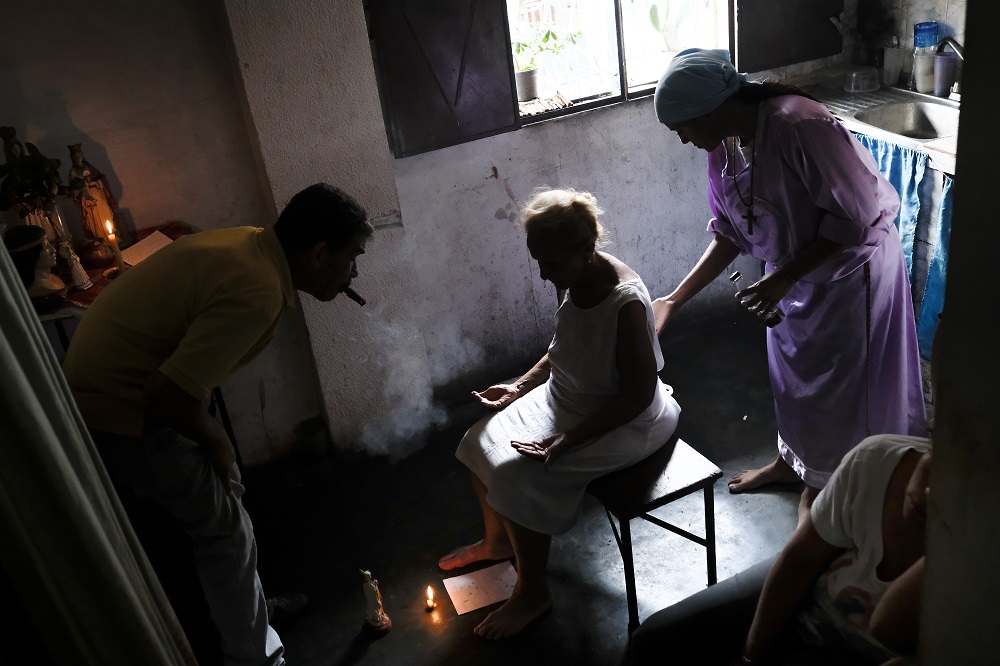 Venezuelan Esperanza Castillo (centre), 74, is treated at the clinic of Venezuelan spiritual healer u00e2u20acu02dcGuayanese Brotheru00e2u20acu2122 in Petare neighbourhood, Caracas September 25, 2019. u00e2u20acu2022 AFP pic