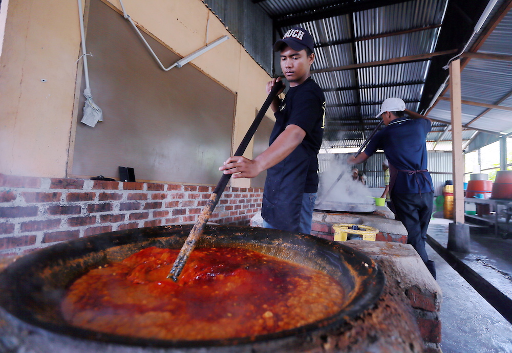 A man cooks rendang tok in Kampung Pasir Putih. — Picture by Farhan Najib