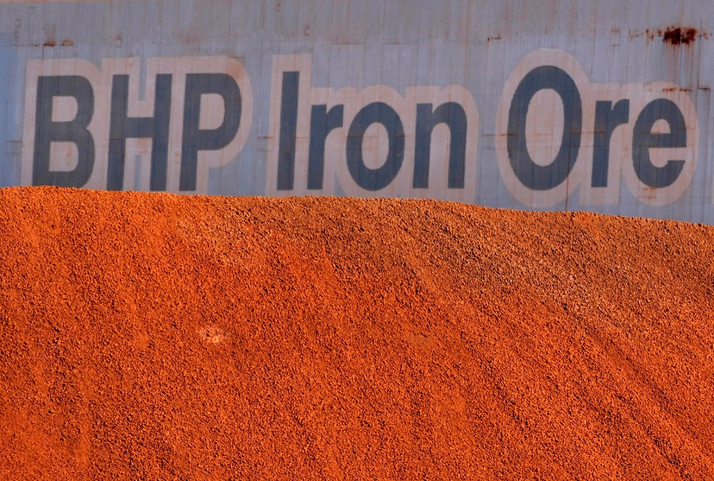 A BHP Billiton sign is visible behind a pile of iron ore at the company's loading facility in Port Hedland, Australia, May 30, 2008. u00e2u20acu201d Reuters pic