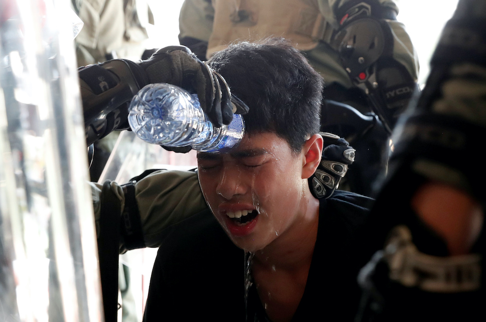 A protester receives help from police officers after being affected by tear gas during an anti-government demonstration in Hong Kong November 10, 2019. u00e2u20acu201d Reuters pic