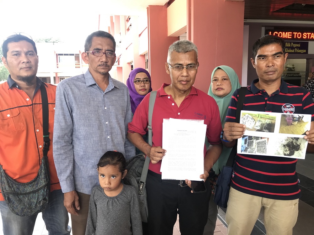 Sahabat Alam Malaysia field officer Meor Razak Meor Abdul Rahman (third left) together with the residents from Segari showing the report and pictures of the flies plaguing the Veterinary Department in Ipoh November 4, 2019. u00e2u20acu201d Picture by John Bunyan 