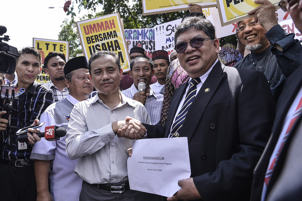PKR chief whip Datuk Johari Abdul accepts a memorandum on behalf of Pakatan Harapan from Ummah chairman Aminuddin Yahaya in front of Parliament November 5, 2019. u00e2u20acu201d Picture by Miera Zulyana