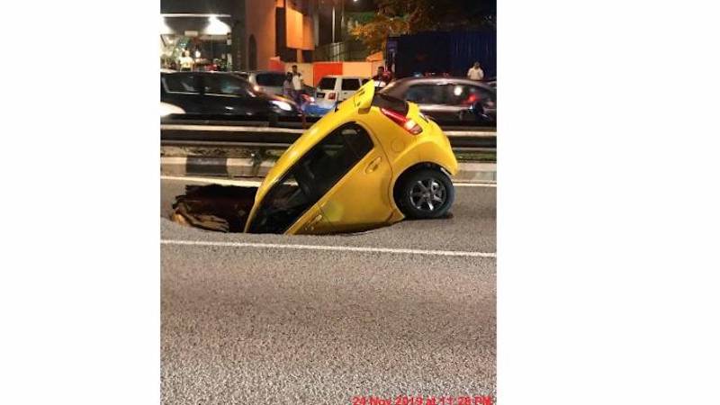 The car in the sinkhole at Jalan Maharajalela heading towards Jalan Loke Yew. u00e2u20acu201d Picture courtesy of Twitter