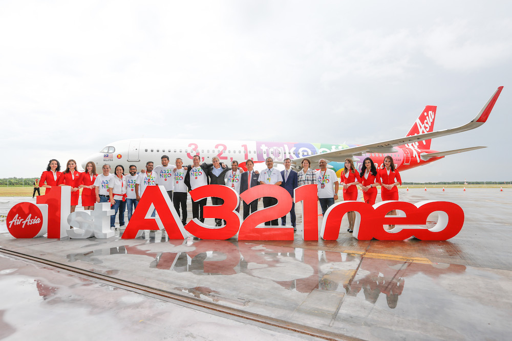 Patrick de Castelbajac, Christian Scherer, Tan Sri Tony Fernandes and Datuk Mohamaddin Ketapi together with AirAsia Group management team flanked by AirAsia cabin crew. u00e2u20acu201d Picture courtesy of AirAsia