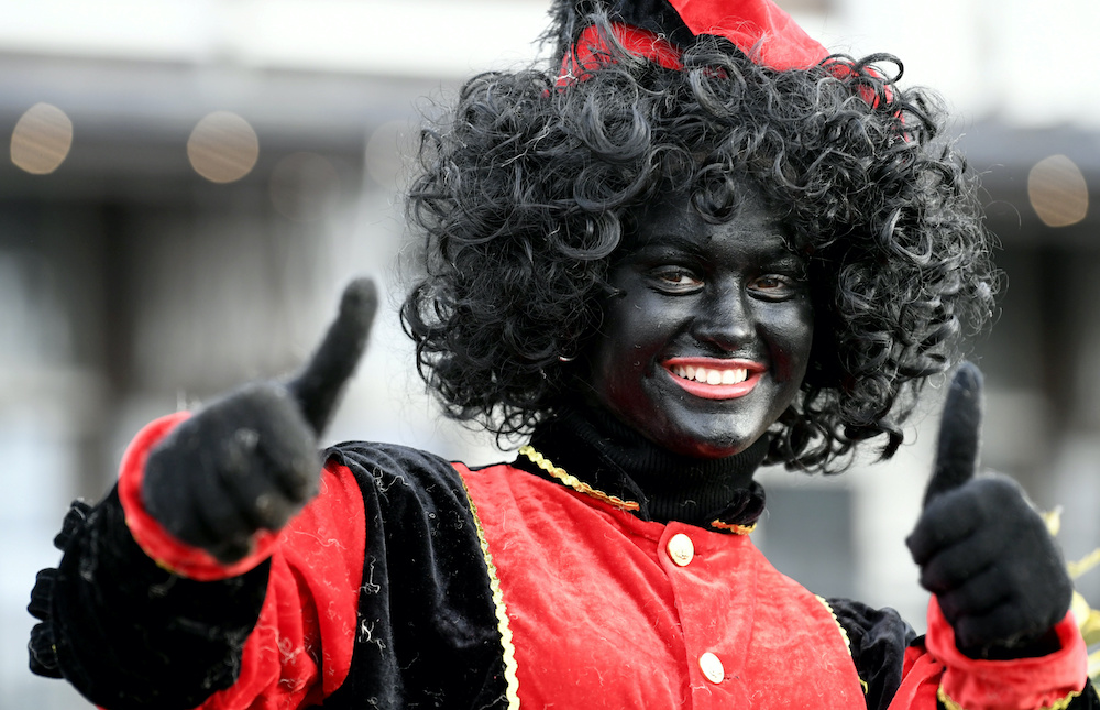 An assistant of Saint Nicholas called u00e2u20acu02dcZwarte Pietu00e2u20acu2122 (Black Pete) gestures as they arrive by boat at the harbour of Scheveningen, Netherlands, November 16, 2019. u00e2u20acu201d Reuters picnn