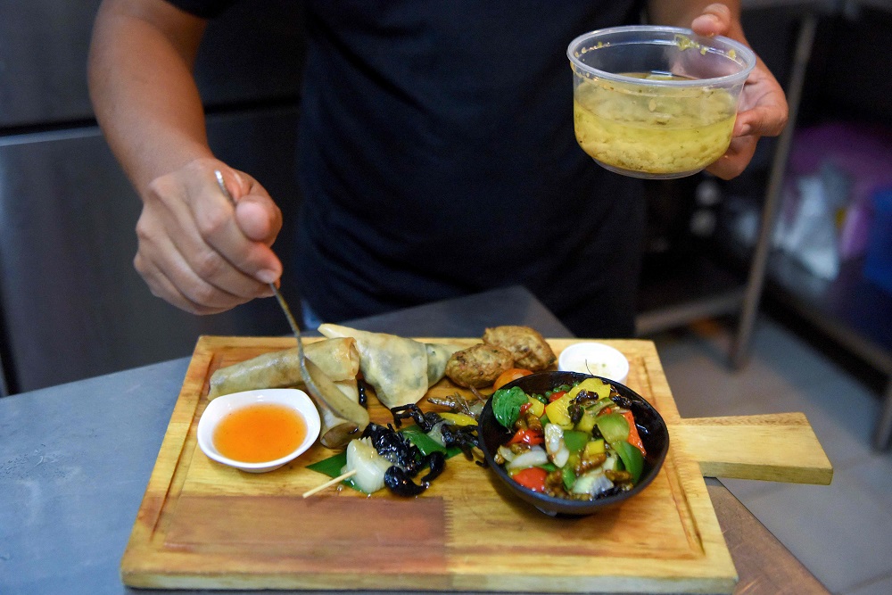 This photo taken on October 24, 2019 shows Chef Seiha Soeun preparing a mixed insect dish with scorpion and spider at the Bugs Cafe restaurant in Siem Reap province. u00e2u20acu201d AFP pic  