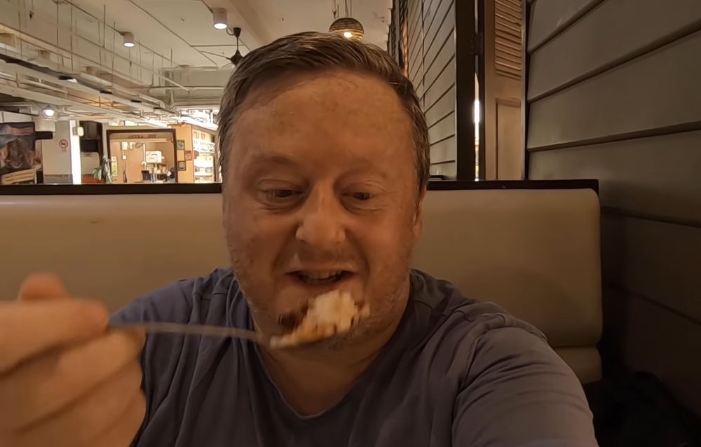 Darren Cronian indulges in a plate of nasi lemak shortly after he arrives in Kuala Lumpur. — Picture via YouTube/remotedarren