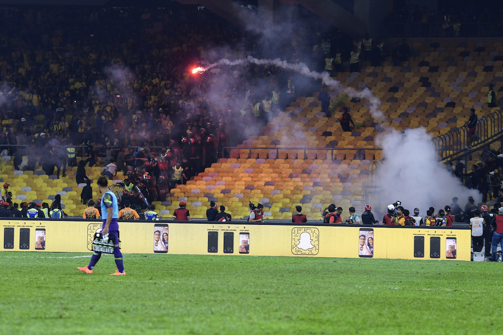 A flare is thrown onto the pitch during the Qatar 2022 Fifa World Cup qualifying match between Malaysia and Indonesia at Bukit Jalil Stadium November 19, 2019. — Bernama pic