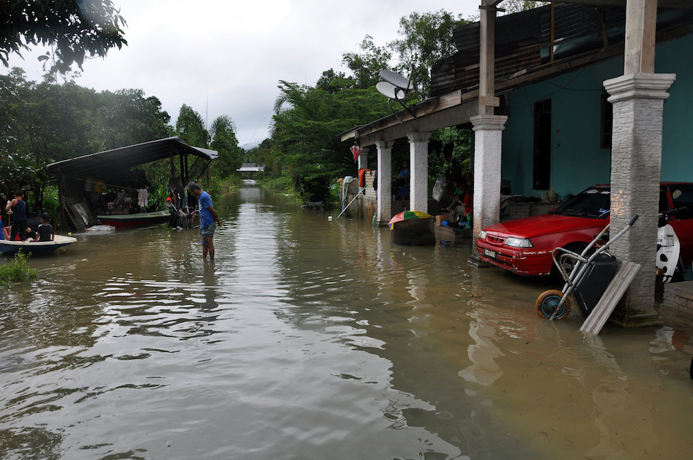 A man wades in calf-deep water in a flooded residential area at Kampung Lepan Kejor in Jerteh, Terengganu November 29, 2019. u00e2u20acu201d Bernama pic