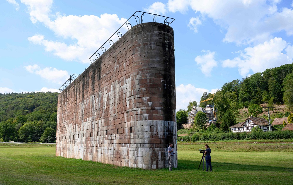 German amateur historian Dieter Stockmann (left) answers an AFP journalist’s questions in front of a large concrete column that was intended to support a bridge along the Route 46, an abandoned motorway from the Nazi era, on August 21, 2019 in the village of Graefendorf near Wuerzburg. — AFP pic  