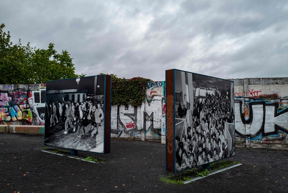 Photographs showing east Germans crossing into west Berlin through the Bornholmer Strasse checkpoint, the first border crossing opened during the fall of the Berlin Wall on the evening of November 9, 1989, are on display near the bridge, October 1, 2019. 