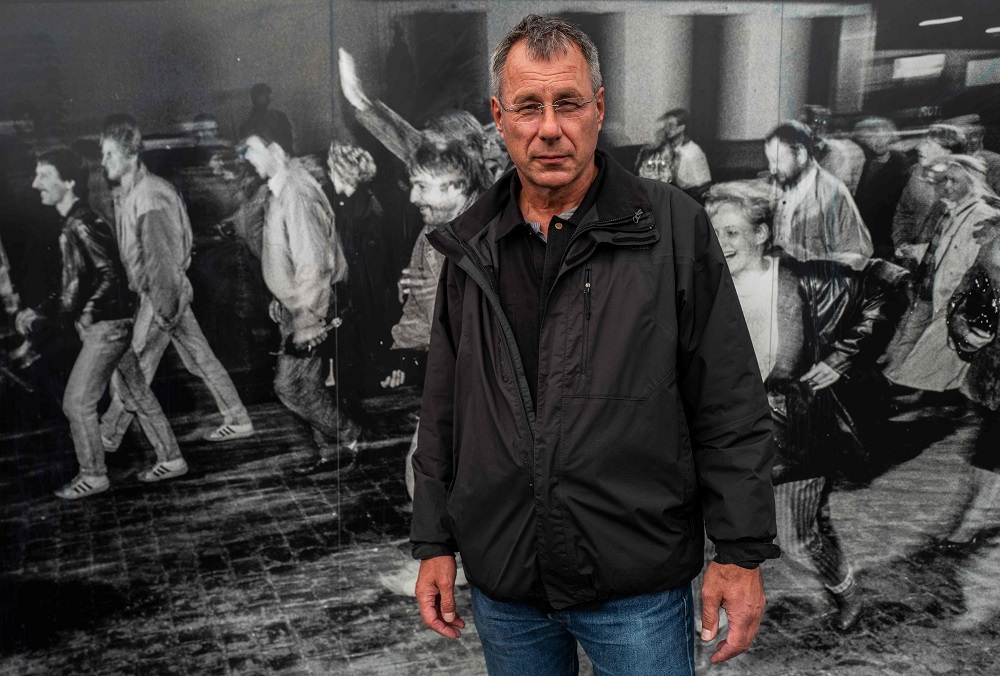 Andreas Falge, one of thousands of east Germans who crossed into west Berlin through the Bornholmer Strasse checkpoint on the evening of November 9, 1989, poses next to a photograph taken that very evening, which forms part of a memorial near the Boesebruecke (Boese bridge) which straddled the border, on October 1, 2019. — AFP pic